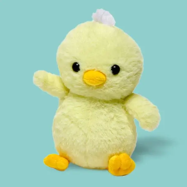 A soft yellow plush chick toy with orange feet and beak, sitting upright against a teal background.